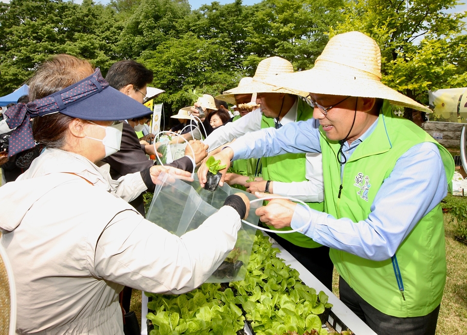 김인중 농림축산식품부 차관이 13일 서울 여의도 국회의사당 헌정기념관 근처에 조성된 ‘국회 생생텃밭’ 개장식 행사에 참석해 참석자들에게 모종을 나눠주고 있다.