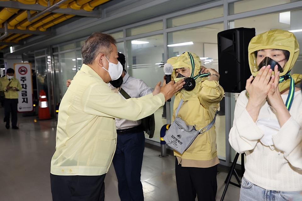이상민 행정안전부 장관이 24일 세종시 정부세종청사에서 자체적으로 실시한 민방공 대피훈련에서 직원들의 방독면 착용을 도와주고 있다.