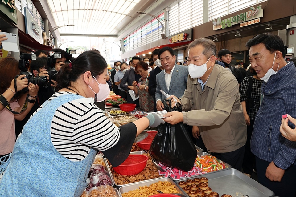 이상민 행정안전부 장관이 30일 울산 중구 태화종합시장을 방문해 과자를 구매하고 있다.