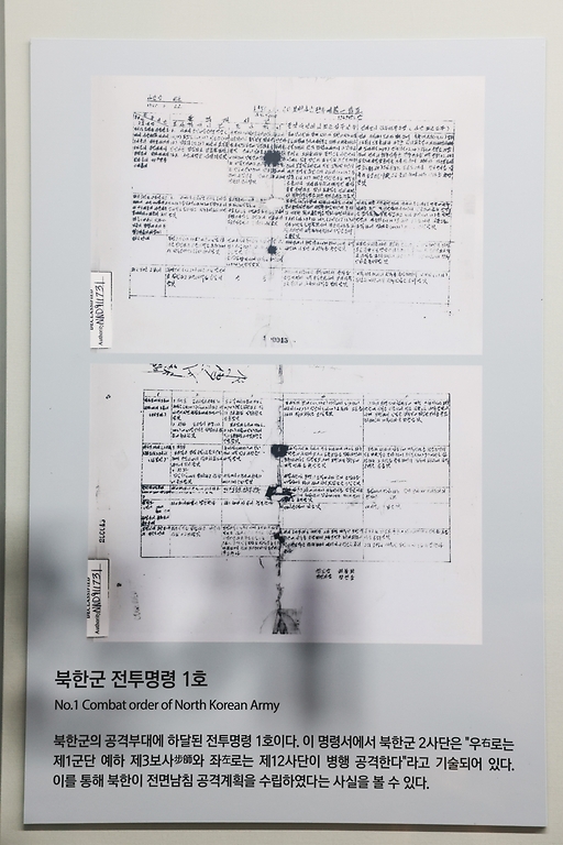 <p> 서울 종로구 대한민국역사박물관 상설전시 역사관 내  6·25 전시 부스가 개편됐다. 상설전시 역사관 6·25 전시는 전쟁의 원인과 발발 책임, 유엔군의 참전 등 국제전의 성격, 전쟁의 결과 및 영향 등을 명확하게 보여주는 체계로 새롭게 구성됐다. 사진은 9일 개편된 6·25 전시 ‘발발과 전개’ 부스 내 ‘북한의 전투 명령 1호’ 문서의 모습.</p>
<div><br></div>