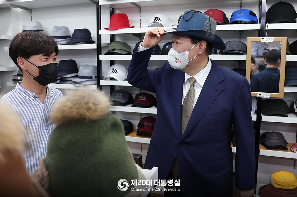 윤석열 대통령이 26일 대구 중구 서문시장을 찾아 한 상점에서 모자를 착용해보고 있다.