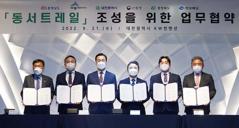 남성현 산림청장(오른쪽 세번째)이 21일 대전 서구 KW컨벤션센터에서 ‘동서트레일’의 성공적 추진을 위한 업무협약을 체결한 후 기념촬영을 하고 있다. 왼쪽부터 전형식 충남 정무부지사, 고기동 세종시 행정부시장, 이택구 대전 행정부시장, 남성현 산림청장, 김명규 충북 경제부지사, 강성조 경북 행정부지사.