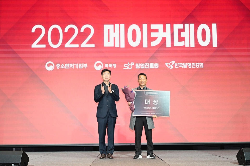 박용순 중소벤처기업부 창업진흥정책관이 24일 서울 구로구 지타워 컨벤션에서 열린 ‘2022 대한민국 메이커스타’ 시상식에서 ‘날개없는 환풍기’를 제출한 ‘더 탑’ 팀에게 대상을 수여하고 기념촬영을 하고 있다. 
