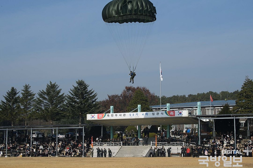 25일 경기 광주시 육군특수전학교 연병장에서 열린 ‘53기 4차 특전부사관 임관식’ 식전 행사에서 특수전학교 교관들이 기구에서 강하해 낙하산을 펼치고 있다. (출처=국방일보)