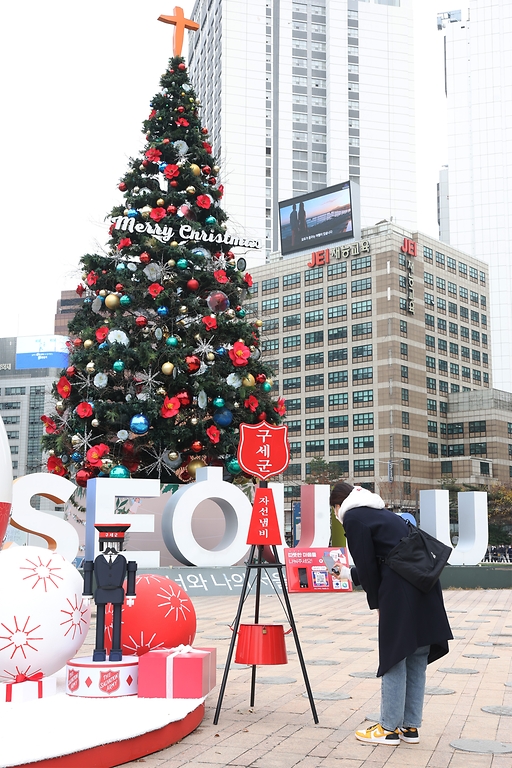 <p>29일 오후 서울광장에서 한 시민이 구세군 나눔카페 자선냄비에 어려운 이웃을 위한 모금에 동참하고 있다.</p>