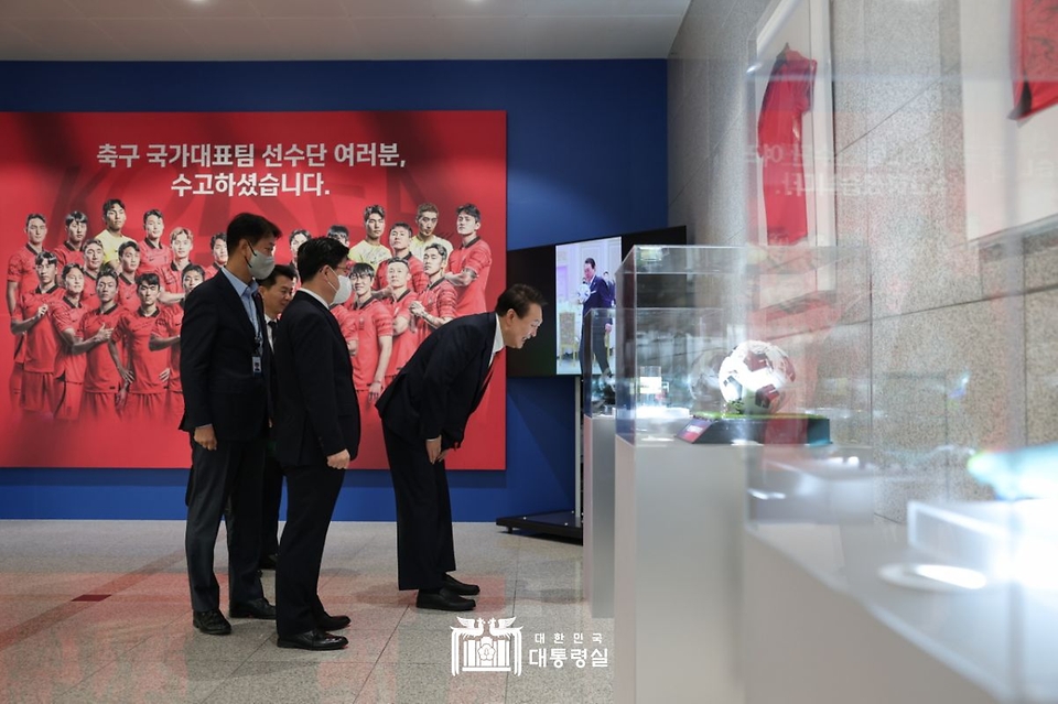 윤석열 대통령이 13일 서울 용산구 대통령실 청사 로비에 전시된 카타르 월드컵 축구 국가대표팀 기념사진 및 기념품을 살펴보고 있다.