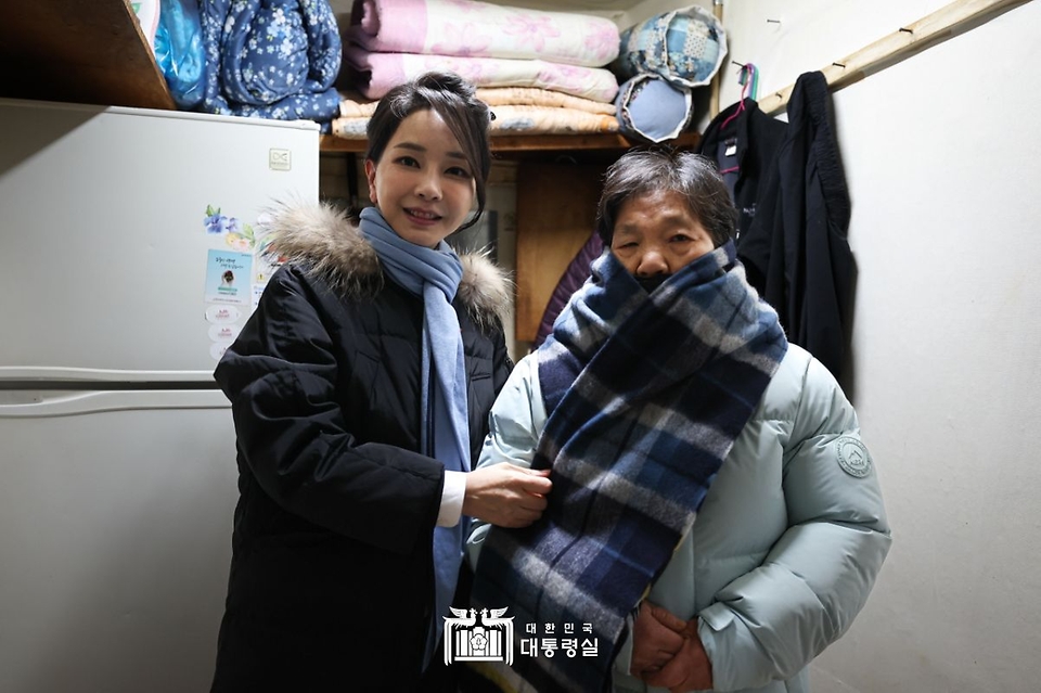 김건희 여사가 22일 ‘2022 찾아가는 성탄절 희망박스 나눔행사’를 위해 서울 용산구 남대문쪽방촌을 찾아 어르신에게 겨울 점퍼와 목도리를 선물하고 있다. 