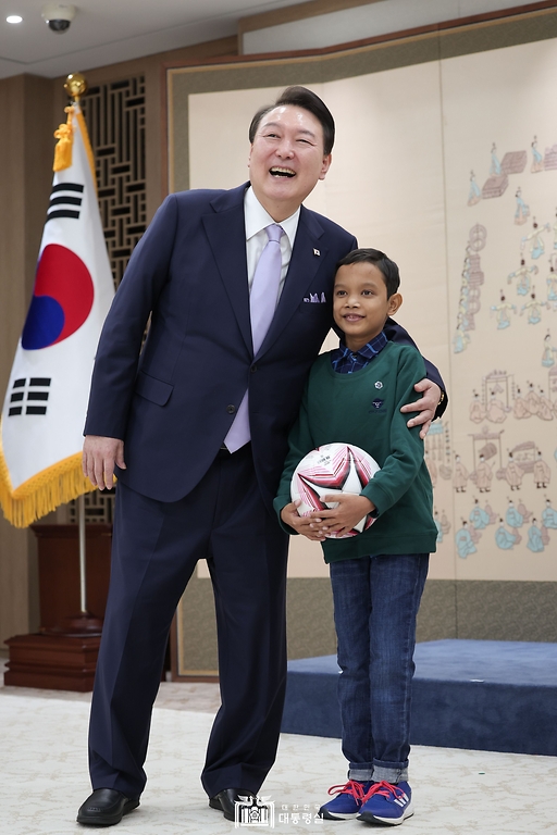 윤석열 대통령이 31일 서울 용산 대통령실 청사에서 심장질환 수술을 받고 회복 중인 캄보디아 소년 로타와 기념촬영을 하고 있다.