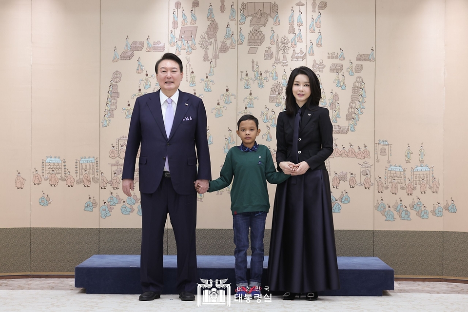 윤석열 대통령과 김건희 여사가 31일 서울 용산 대통령실 청사로 심장질환 수술을 받고 회복 중인 캄보디아 소년 로타를 초청, 기념촬영을 하고 있다.