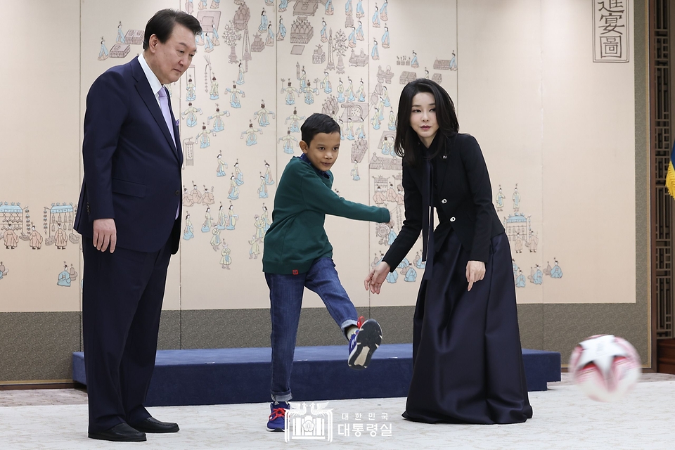 윤석열 대통령과 김건희 여사가 31일 서울 용산 대통령실 청사에서 심장질환 수술을 받고 회복 중인 캄보디아 소년 로타가 공을 차고 있는 모습을 바라보고 있다.