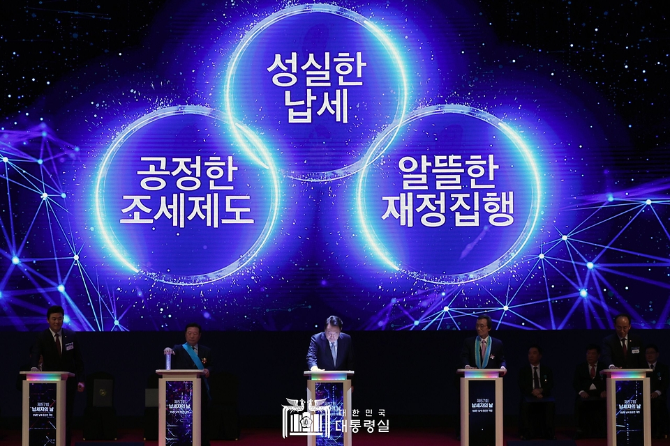 윤석열 대통령이 3일 서울 강남구 코엑스에서 열린 ‘제57회 납세자의 날 기념식’에서 참석자들과 성실납세를 약속하는 세리머니를 하고 있다.