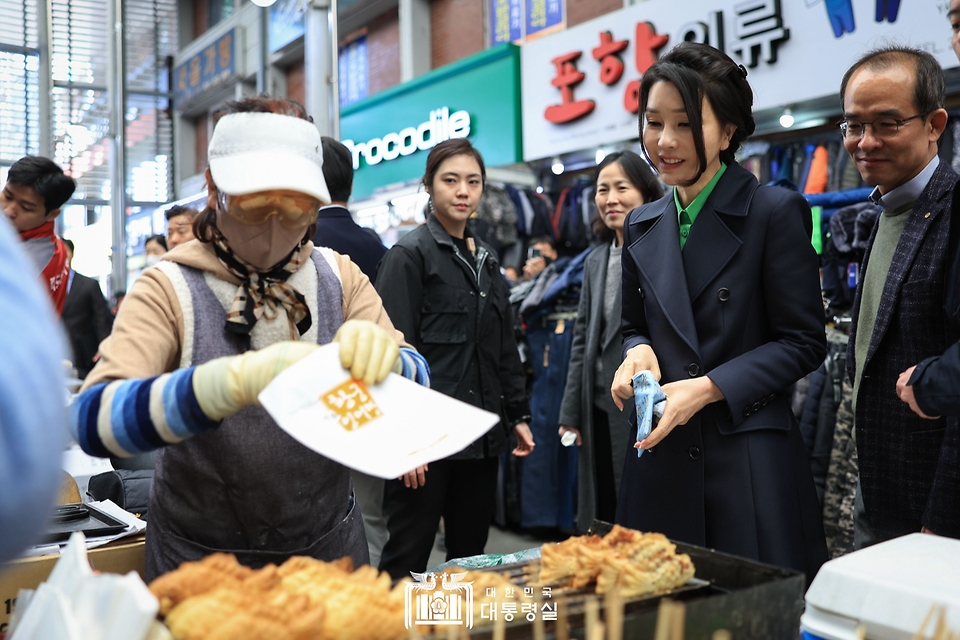 김건희 여사가 3일 경북 포항시 북구 죽도시장을 방문해 붕어빵을 구입하고 있다.