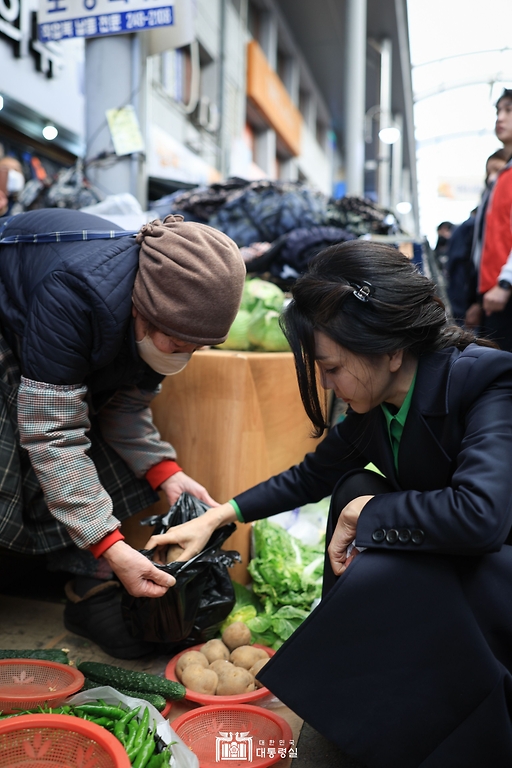 김건희 여사가 3일 경북 포항시 북구 죽도시장을 방문해 감자를 구입하고 있다.
