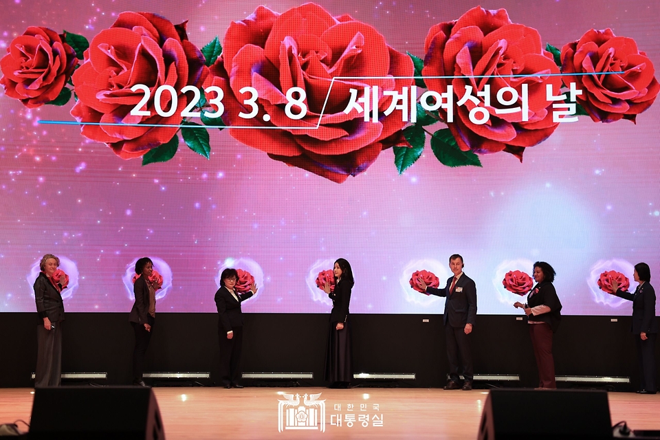 김건희 여사가 8일 서울 강남구 코엑스에서 열린 세계여성의날 기념식에서 LED화면에 등장한 장미꽃을 누르는 퍼포먼스를 하고 있다.
