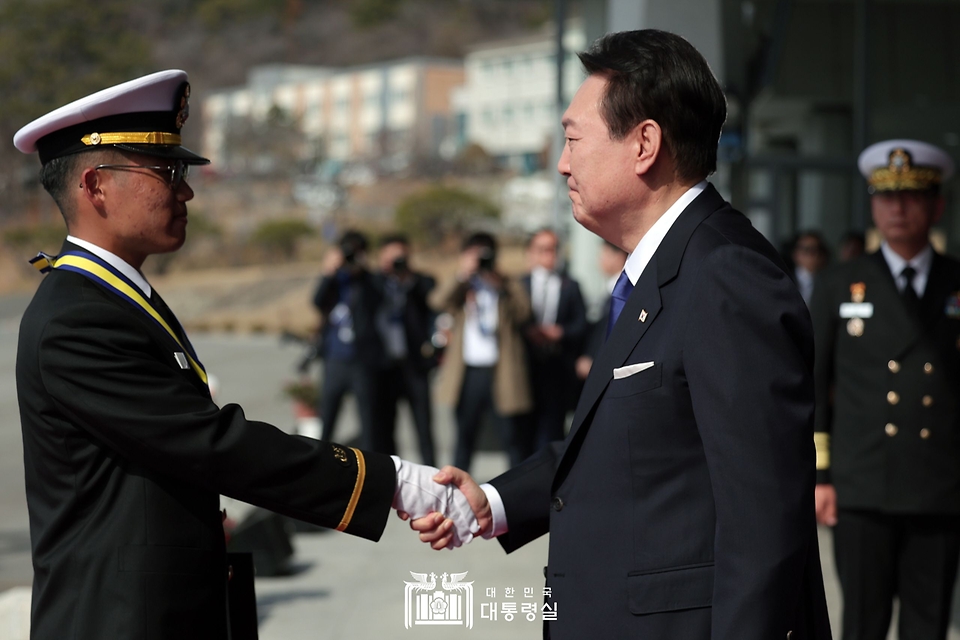 윤석열 대통령이 10일 경상남도 창원시 진해구 해군사관학교에서 열린 제77기 졸업 및 임관식에 참석해 우수 졸업생인 강녕한 소위에게 메달을 걸어준 뒤 악수하고 있다. 