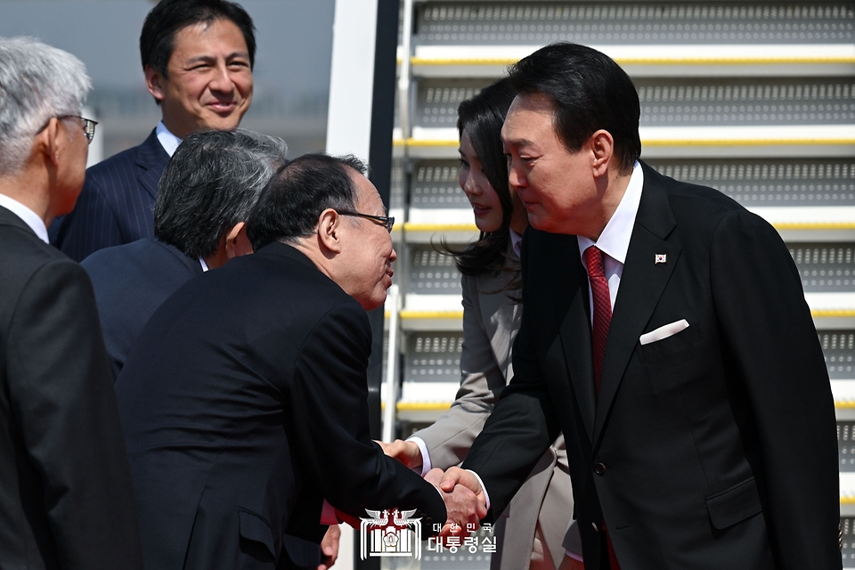 윤석열 대통령과 김건희 여사가 16일 일본 도쿄 하네다공항에 도착해 환영인사들과 인사하고 있다.