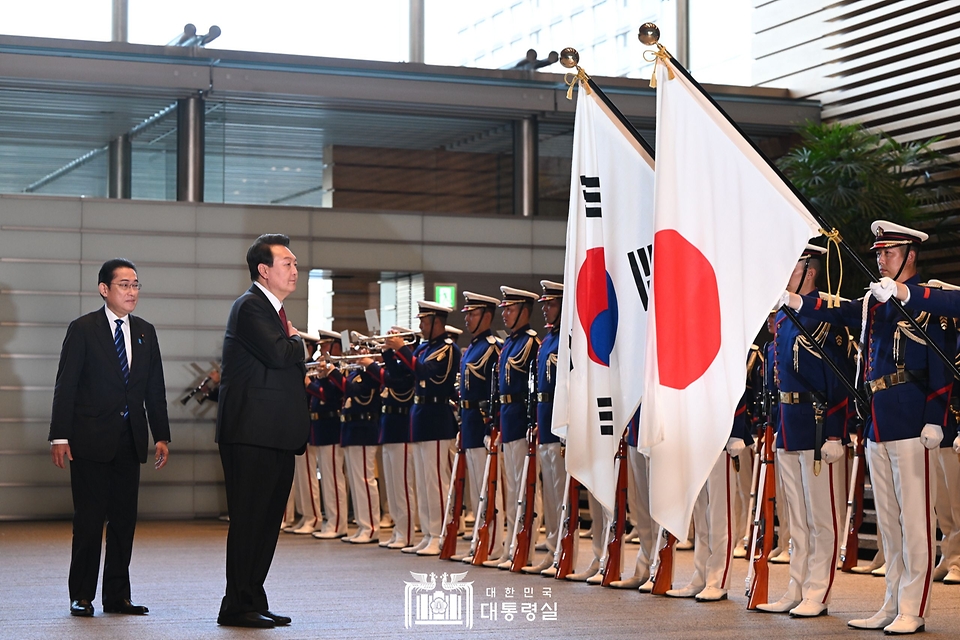 윤석열 대통령이 16일 일본 도쿄 총리 관저에서 기시다 후미오 총리와 의장대 사열에 앞서 국기에 경례하고 있다.
