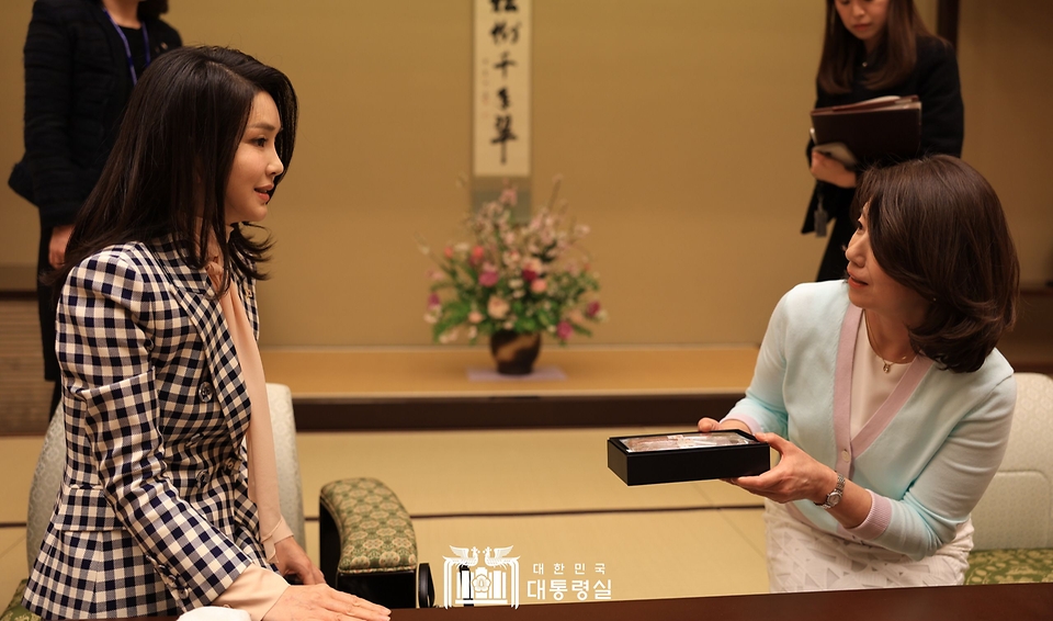 김건희 여사가 16일 도쿄 총리 공저에서 기시다 유코 여사에게 선물을 전달받고 있다.