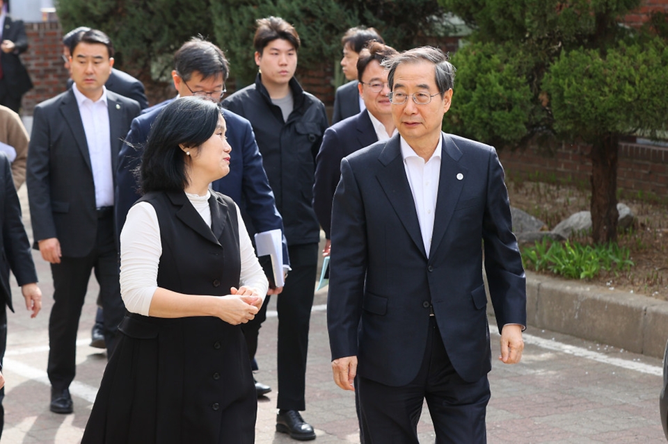 한덕수 국무총리가 24일 서울 구로구 구로삼성어린이집으로 이동하며 관계자와 대화하고 있다.