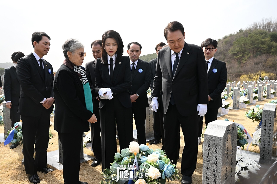 윤석열 대통령과 부인 김건희 여사가 24일 대전시 유성구 국립대전현충원에서 천안함 46용사 고 민평기 상사의 묘비를 살펴보고 있다.