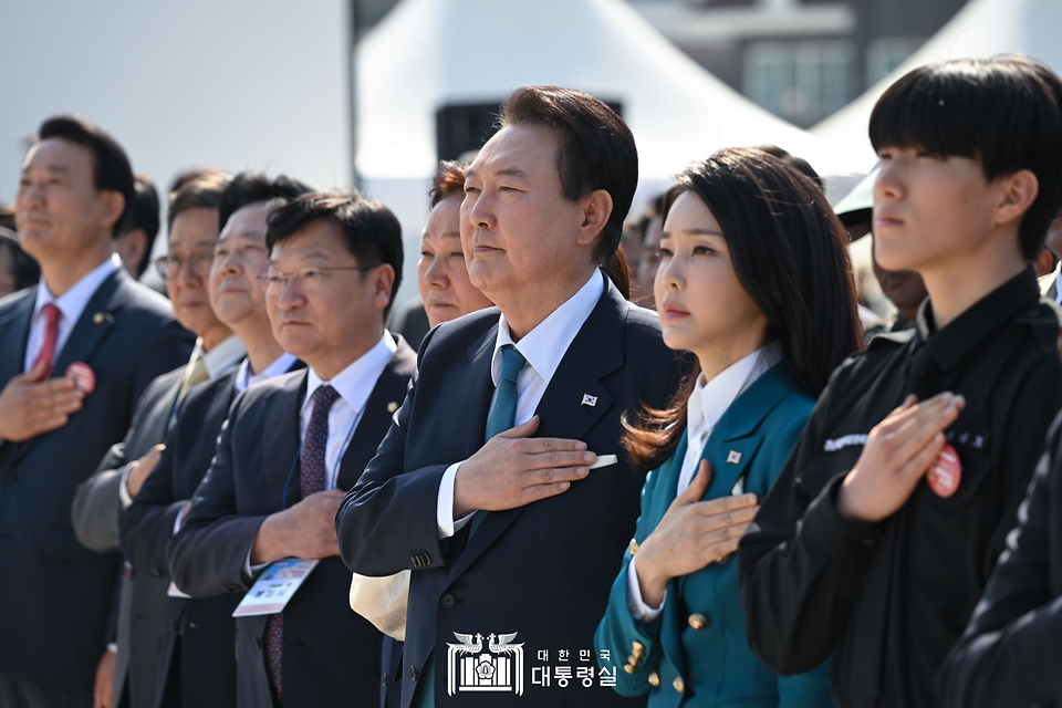 윤석열 대통령과 김건희 여사가 31일 경남 통영시 영운항에서 열린 제12회 수산인의 날 기념식에서 국기에 대한 경례를 하고 있다.
