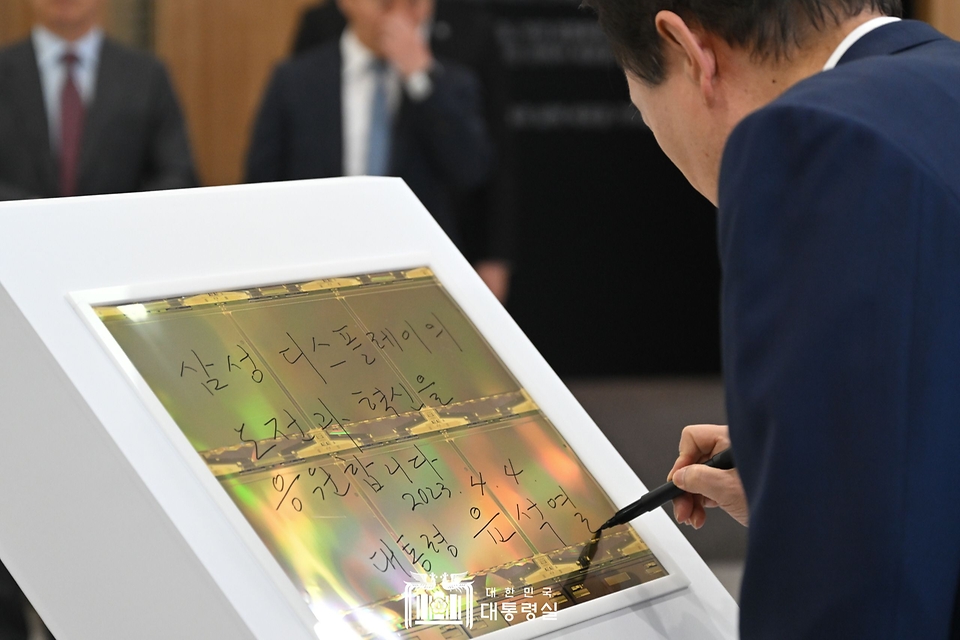 윤석열 대통령이 4일 충남 아산시 삼성디스플레이에서 열린 ‘삼성디스플레이 투자협약식’에 앞서 OLED패널에 방명록을 작성하고 있다.