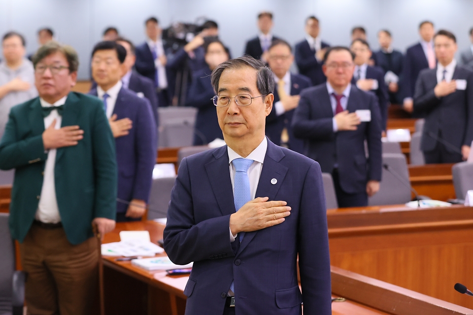 한덕수 국무총리가 10일 서울 종로구 정부서울청사에서 열린 ‘2050탄소중립녹색성장위원회 전체회의’에서 국기에 대한 경례를 하고 있다.