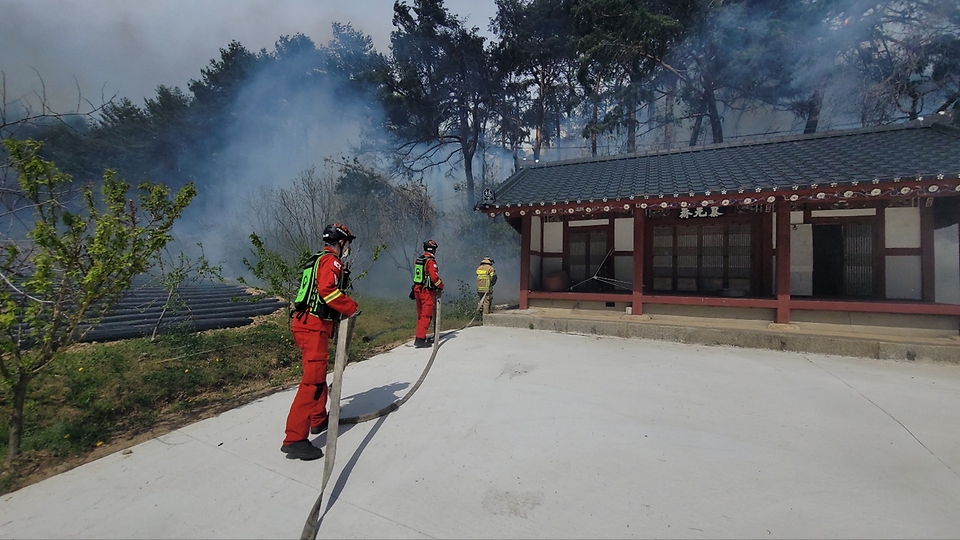 산림청 공중진화대원들이 11일 강원 강릉시 난곡동 야산에서 발생한 산불을 막기위해 물을 뿌리며 제실을 방어하고 있다.