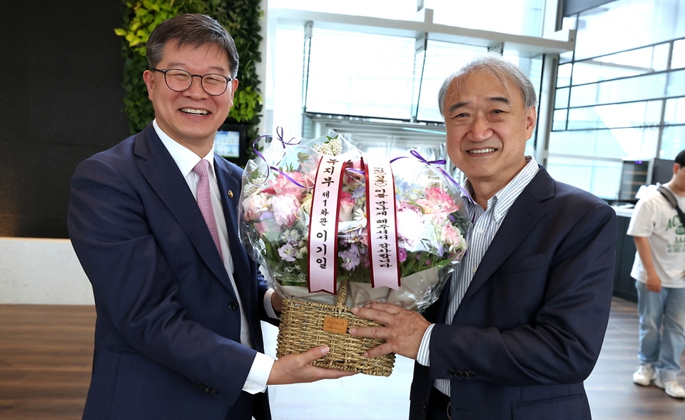 이기일 보건복지부 1차관이 18일 서울 종로구 SK온에서 국내 최초 초산 자연분만 네쌍둥이의 탄생을 축하하며 분만을 집도한 전종관 서울대학교병원 산부인과 교수에게 꽃바구니를 전달하고 있다.