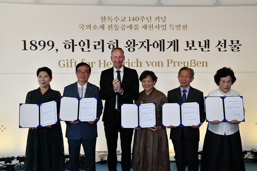 19일 서울 중구 덕수궁 덕홍전에서 열린 한·독 수교 140주년 기념 국외소재 전통공예품 재현 사업 특별전 ‘1899, 하인리히 왕자에게 보낸 선물’ 개막식에서 홀가 게어만 포르쉐코리아 대표가 국가무형문화재 보유자와 보유단체에게 총 3천만원의 전승지원금을 전달하고 있다.