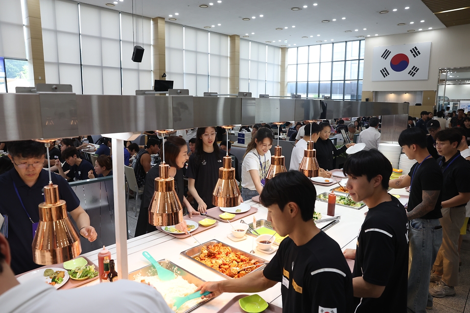 <p>4일 충북 진천국가대표선수촌에서 열린 '우리수산물 전달행사'에서 국가대표 선수들과 가족들이 보양식을 먹기 위해 줄지어 서 있다. 이번 행사는 항저우 아시안게임 50일을 앞두고 대회에 참가하는 국가대표 선수들과 가족을 격려하기 위해 마련됐다.</p>