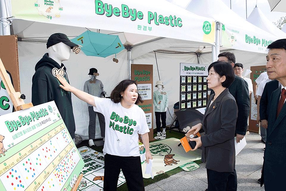 한화진 환경부 장관이 6일 충남 아산시 아산환경과학공원에서 열린 ‘제15회 자원순환의 날 기념식’에 참석, 부대행사로 마련된 전시 부스를 둘러보며 페트병으로 만든 의류에 대한 관계자의 설명을 듣고 있다.