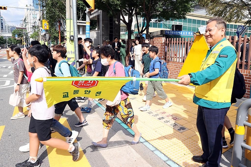 이상민 행정안전부 장관이 18일 서울 성동구 경동초등학교 앞 등-하교길 어린이 보호구역 교통안전 캠페인에서 횡단보도 건널목 교통지도를 하고 있다.