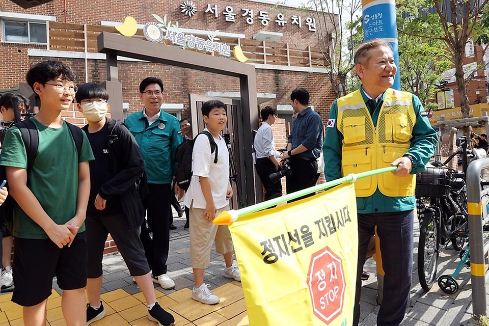 이상민 행정안전부 장관이 18일 서울 성동구 경동초등학교 앞 등-하교길 어린이 보호구역 교통안전 캠페인에서 횡단보도 건널목 교통지도를 하고 있다.