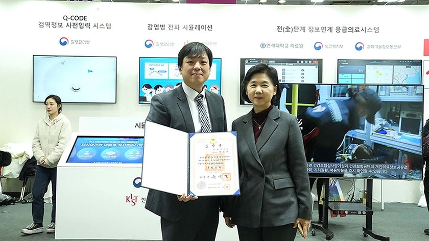 지영미 질병관리청장이 25일 부산 해운대구 벡스코에서 열린 ‘2023 대한민국 정부 박람회 대국민 보고대회’에 참석해 세계 최초로 ‘코로나19 전자예방접종 증명서’를 개발한 정우진 정보통계담당관에게 근정포장을 수여한 뒤 기념촬영을 하고 있다.