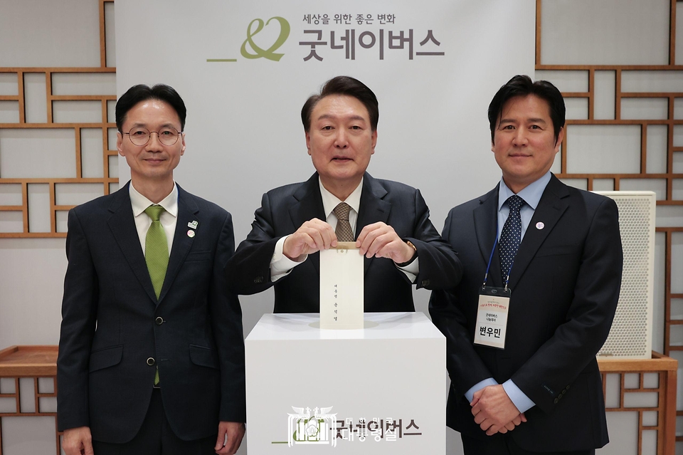 윤석열 대통령이 4일 서울 용산구 대통령실 청사에서 열린 ‘2023년 기부·나눔 단체 초청 행사’에서 굿네이버스에 성금을 기부하고 있다. 왼쪽은 굿네이버스 김중곤 사무총장, 오른쪽은 굿네이버스 나눔대사 변우민. 