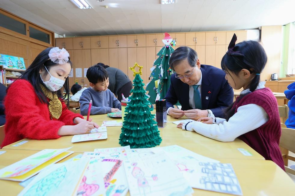 한덕수 국무총리가 22일 경기도 성남시 성남장안초등학교에서 시범 운영 중인 늘봄학교를 방문해 어린이들과 함께 크리스마스 카드를 만들고 있다.