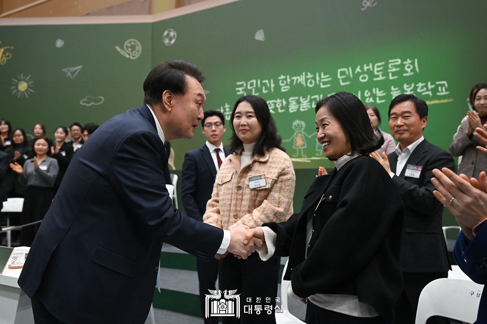 윤석열 대통령이 5일 경기도 하남시 신우초등학교에서 열린 ‘국민과 함께하는 민생토론회 - 아홉 번째, 따뜻한 돌봄과 교육이 있는 늘봄학교’에서 참석자와 악수하고 있다.