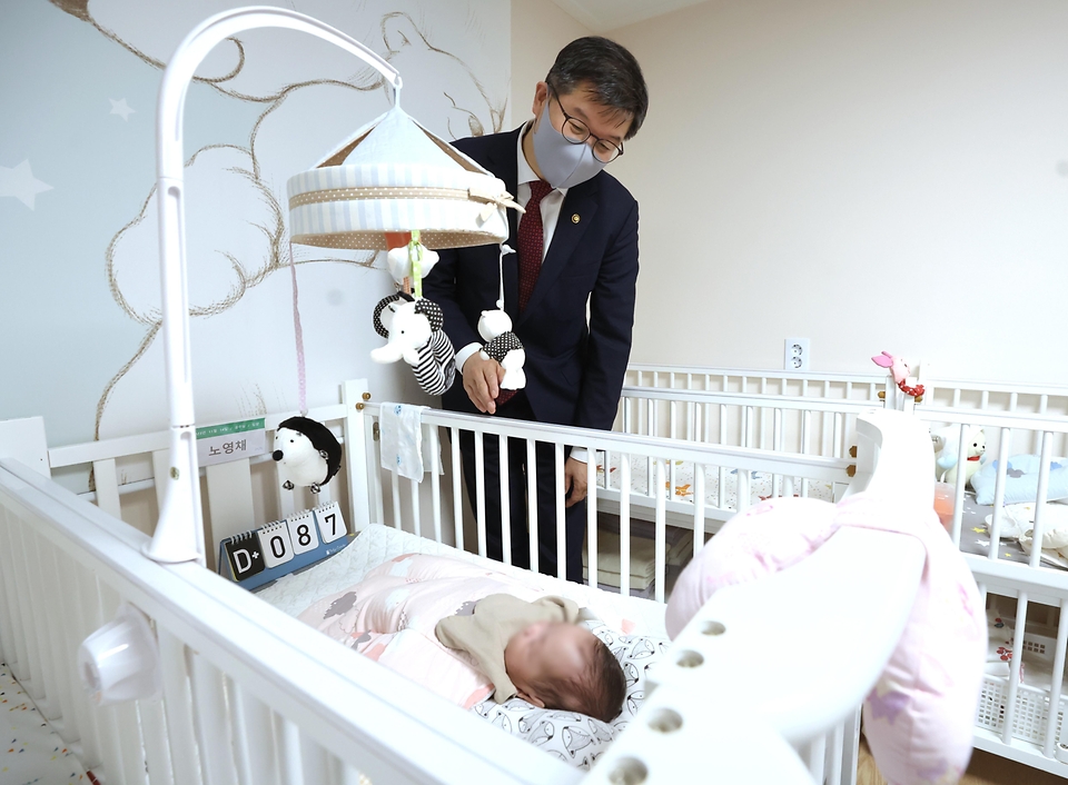 이기일 보건복지부 1차관이 8일 관악구 소재 재단법인 주사랑공동체(베이비박스 운영기관)를 방문하여 아기를 보고 있다.