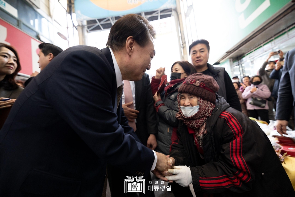 윤석열 대통령이 22일 경남 창원시 마산합포구 마산어시장을 방문해 상인과 인사를 나누고 있다.