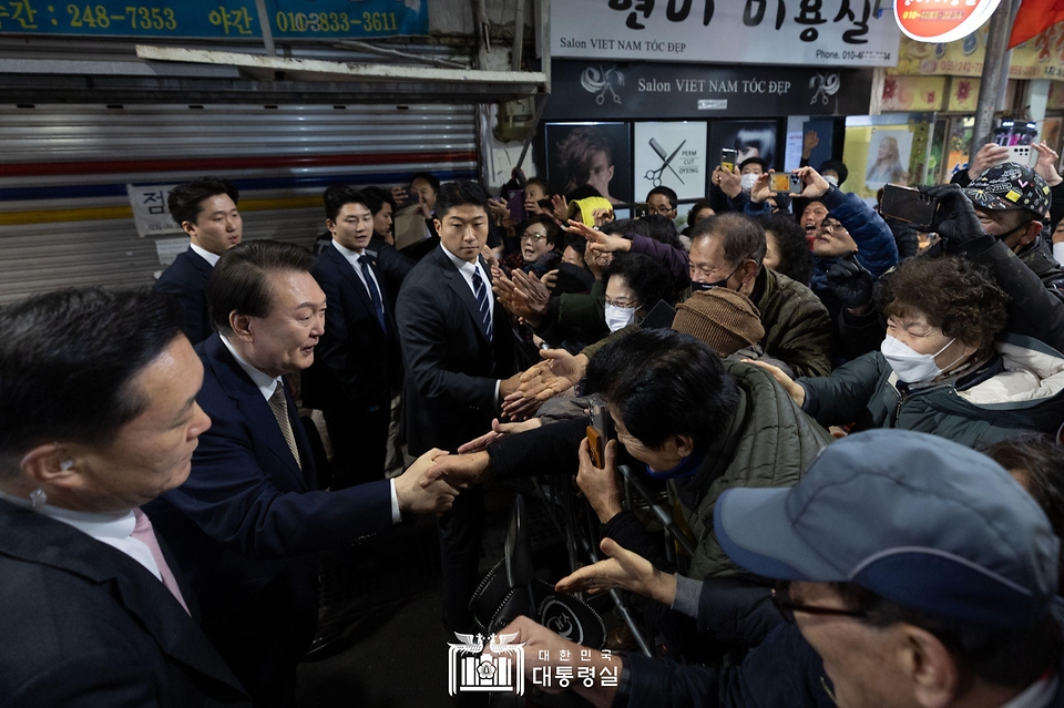 윤석열 대통령이 22일 경남 창원시 마산합포구 마산어시장을 방문해 시민들과 인사를 나누고 있다.