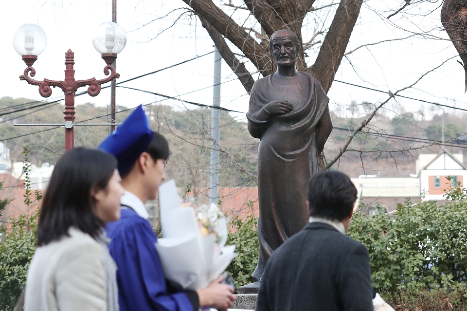 <p>정부의 의과대학 증원에 반발해 전공의들의 사직서 제출이 이어지고 있는 가운데 27일 오후 서울 종로구 서울대학교 연건캠퍼스에서 열린 서울대학교 의과대학·대학원 학위수여식에서 졸업생들이 히포크라테스 동상을 지나가고 있다. </p>