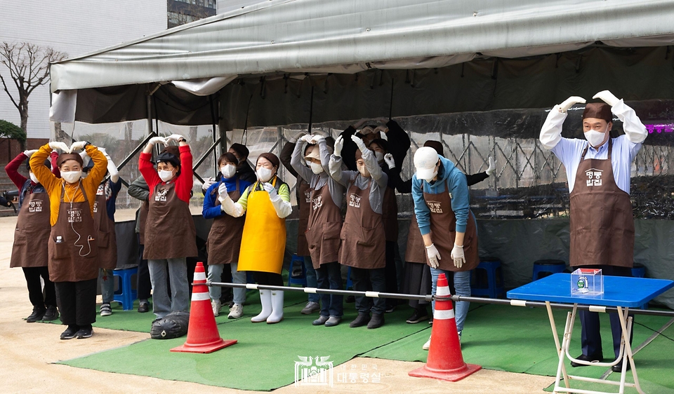 윤석열 대통령이 27일 서울 명동성당 내 무료 급식소인 ‘명동밥집’을 찾아 배식에 앞서 봉사자들과 함께 명동밥집을 찾은 시민들에게 인사하고 있다.