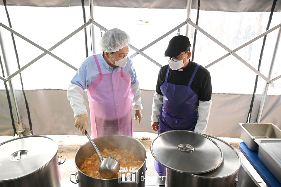 윤석열 대통령이 27일 서울 명동성당 내 무료 급식소인 ‘명동밥집’에서 명동밥집 센터장 백광진 신부와 김치찌개를 조리하고 있다.