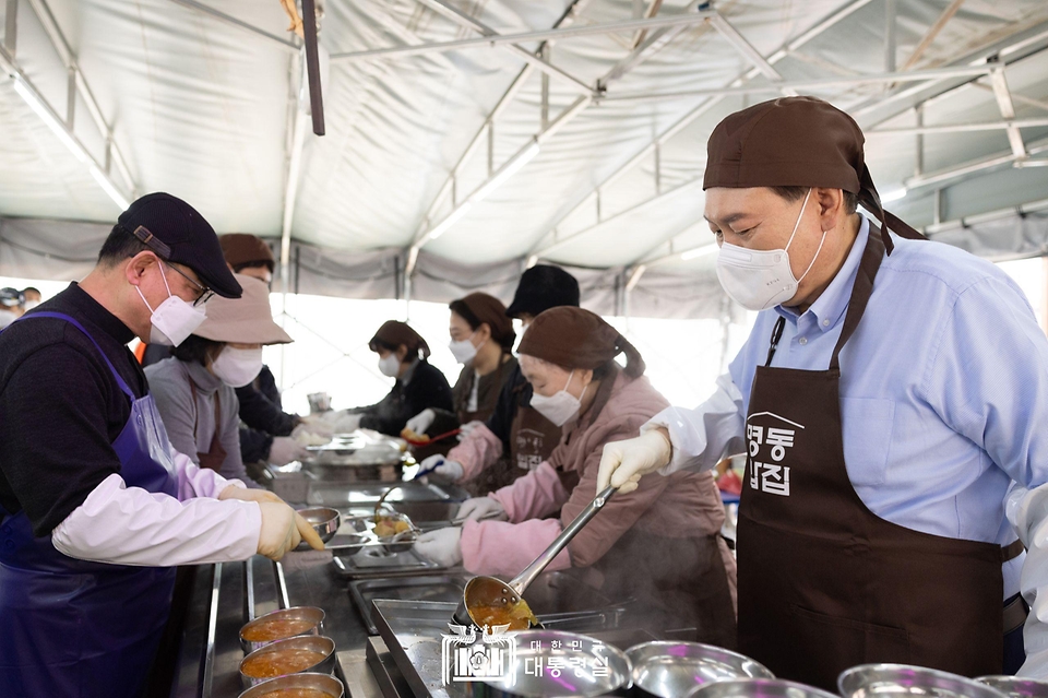 윤석열 대통령이 27일 서울 명동성당 내 무료 급식소인 ‘명동밥집’을 찾아 야외 배식장에서 배식 봉사를 하고 있다.