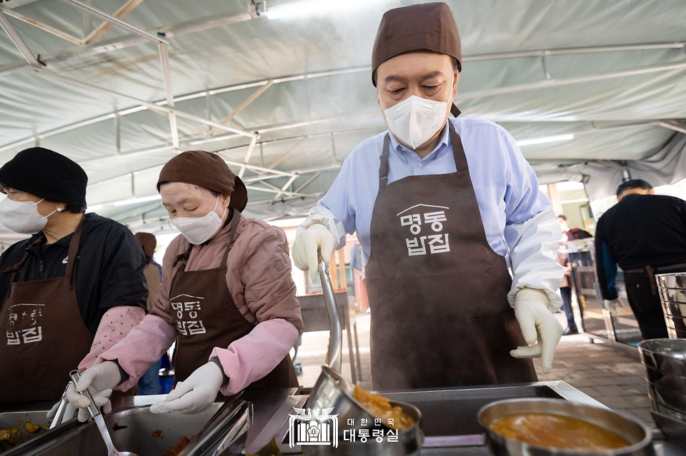 윤석열 대통령이 27일 서울 명동성당 내 무료 급식소인 ‘명동밥집’을 찾아 야외 배식장에서 배식 봉사를 하고 있다.