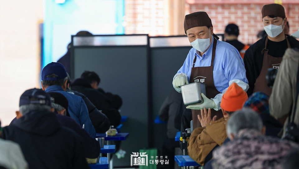 윤석열 대통령이 27일 서울 명동성당 내 무료 급식소인 ‘명동밥집’에서 봉사활동을 펼치며 추가 배식 희망자를 찾아 오가고 있다.