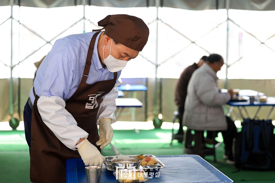 윤석열 대통령이 27일 서울 명동성당 내 무료 급식소인 ‘명동밥집’에서 봉사활동을 펼치며 배식을 받아 급식장 내 빈 테이블에 식판을 놓고 있다.