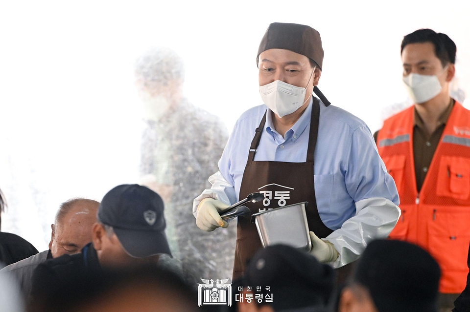 윤석열 대통령이 27일 서울 명동성당 내 무료 급식소인 ‘명동밥집’에서 봉사활동을 펼치며 추가 배식 희망자를 찾아 오가고 있다.