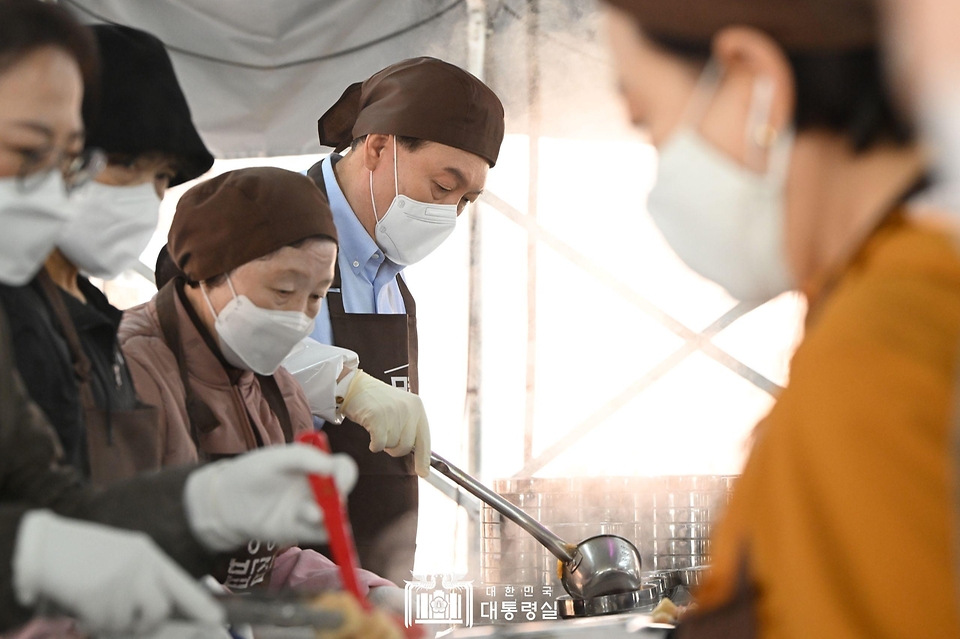 윤석열 대통령이 27일 서울 명동성당 내 무료 급식소인 ‘명동밥집’을 찾아 야외 배식장에서 배식 봉사를 하고 있다.